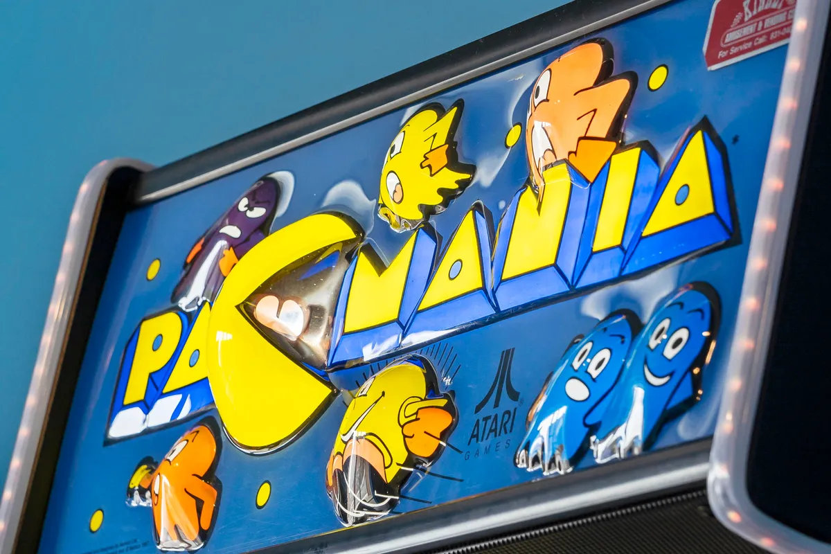 A classic Pac-Man arcade machine with colorful graphics stands ready for play, evoking nostalgia and excitement. The vibrant, retro design hints at game nights and friendly competitions among guests.